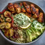 Plated Paprika Roasted Vegetable Quinoa Bowl with golden chicken, creamy avocado, and crisp lemon salad for a vibrant, healthy meal.