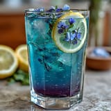 Magical butterfly pea flower lemonade transforms from deep blue to purple when citrus meets ice and fresh lemon juice.