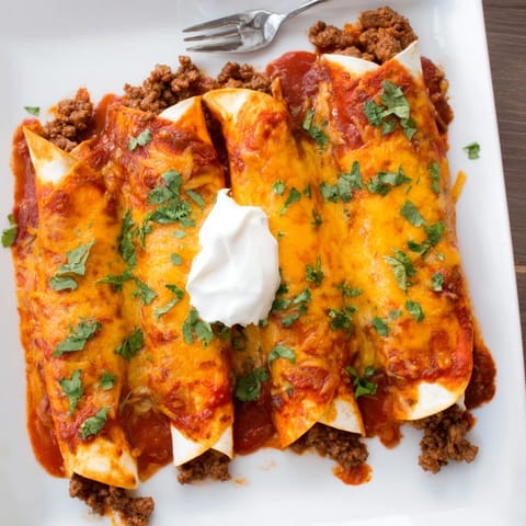 Golden baked Beef Enchiladas filled with seasoned ground beef, cheese, and rich red sauce, served with sour cream.