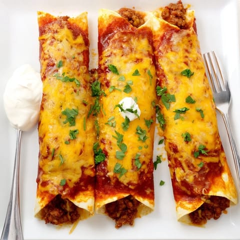 A casserole dish of Beef Enchiladas with bubbly cheese topping and fresh cilantro garnish on a rustic table.