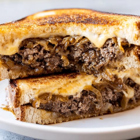 Melting Swiss cheese stretches over a tender beef patty, tucked inside golden, crispy grilled bread.