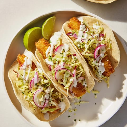 A plate of golden Grilled Fish Tacos topped with crunchy cabbage and fresh cilantro.