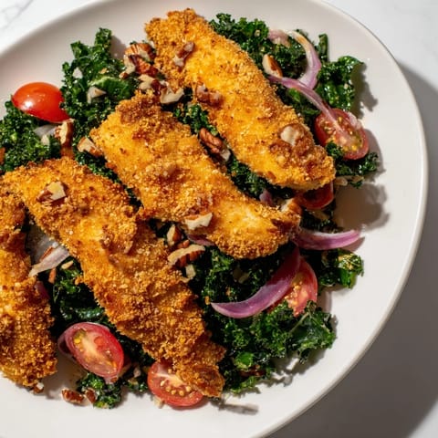 This hearty Crispy Chicken Kale Salad features golden-brown breaded cutlets atop massaged kale, tossed with sweet and tangy maple-Dijon vinaigrette for a satisfying meal.  