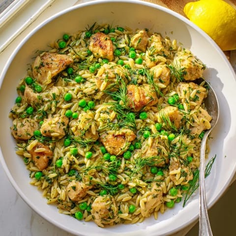 A finished skillet of Lemon Herb Chicken Orzo with tender chicken, peas, and herbs, ready to serve for a light spring dinner.  