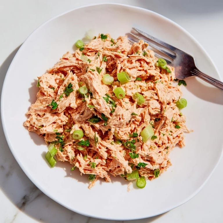A close-up view of Spicy Zesty Tuna Salad revealing flaky fish, diced celery, and vibrant scallions for a crunchy bite.
