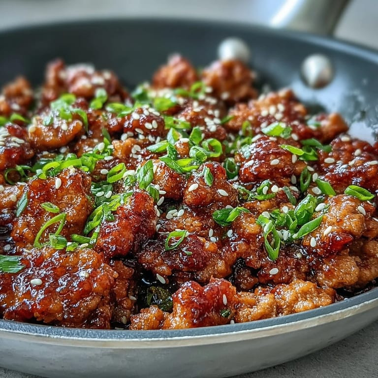 Sizzling skillet of Korean-Style Ground Turkey with garlic and ginger, ready to serve with sautéed broccoli and carrots.